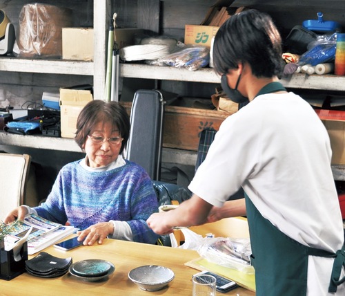 店員として来店客にコーヒーを提供