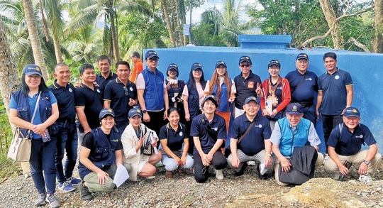 完成した貯水タンクの前で記念撮影をする関係者ら