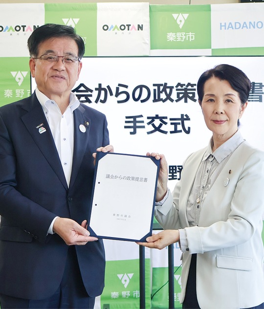 高橋市長（左）に提言書を手渡す横山議長