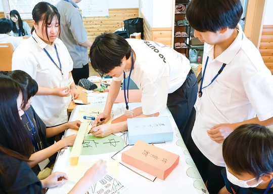 色画用紙などを使って立体的に理想の学校を作っていく参加者ら