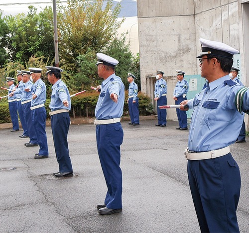 交通誘導の動作を確認する交通指導員