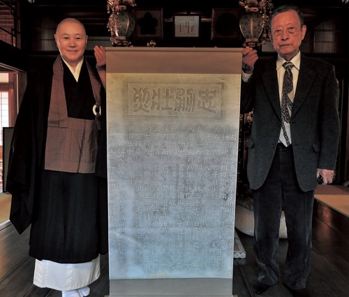表装した拓本を東島住職（左）に渡す石川さん