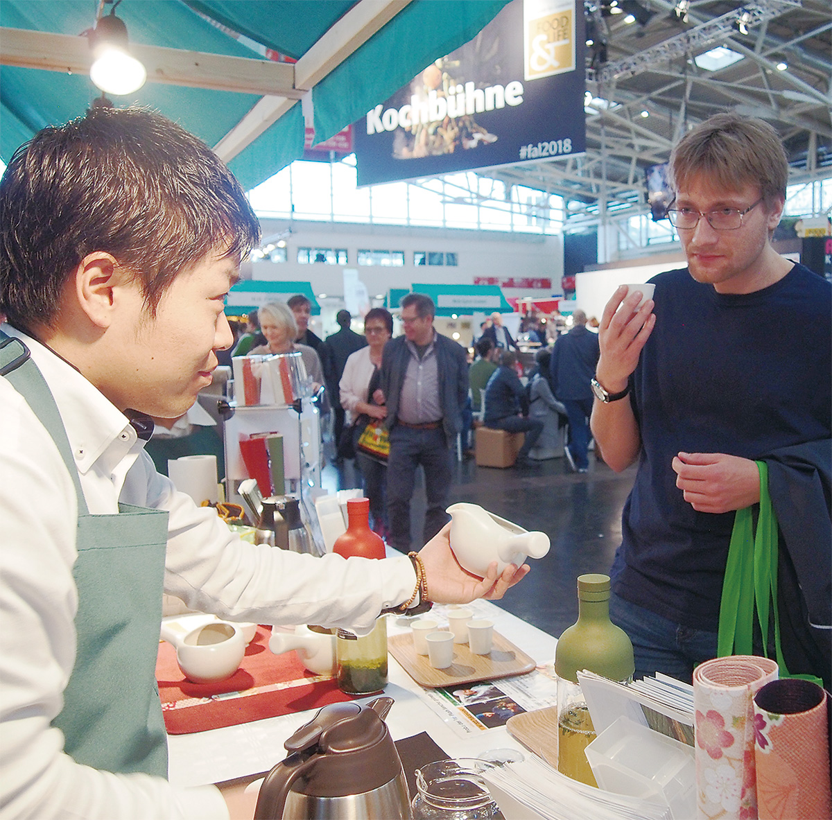 ドイツ・ミュンヘンのFOOD&LIFEの出展ブースで来場者に日本茶の魅力を伝える高梨晃さん(左)