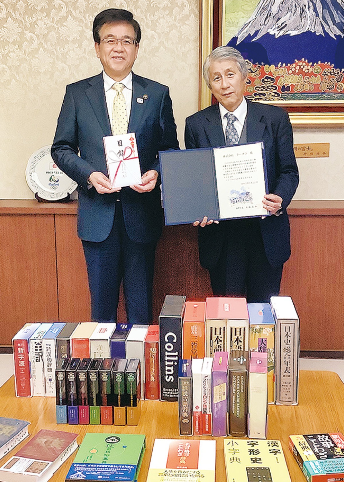 千川社長(右)が市長に目録を贈呈