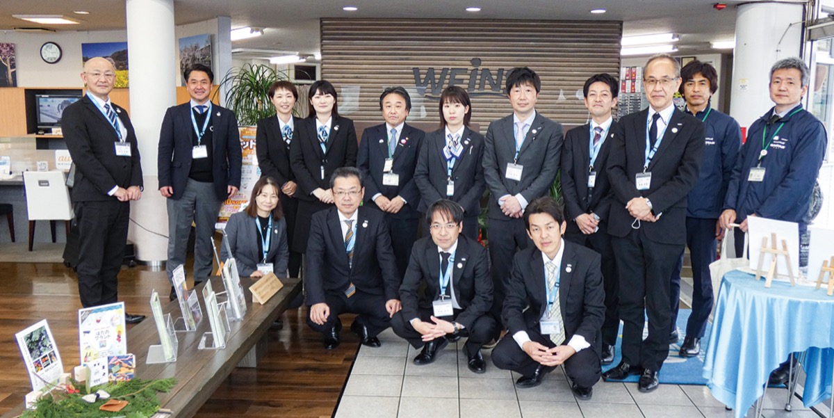秦野産材を使った什器(左手前)とスタッフ、内覧会参加者ら
