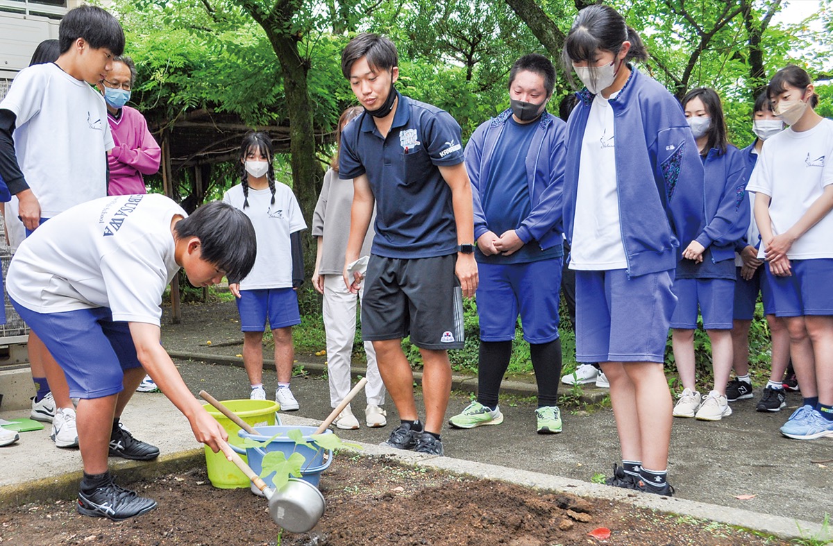植えた被爆アオギリ二世に水をあげる生徒