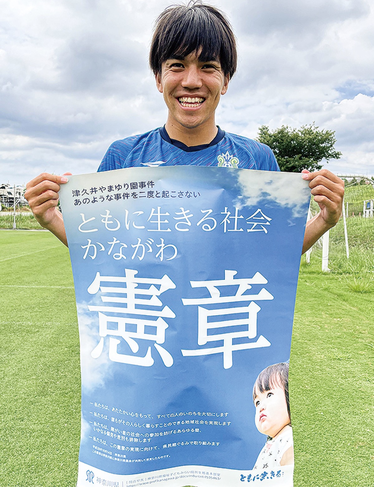 憲章ポスターを持つ田中聡選手